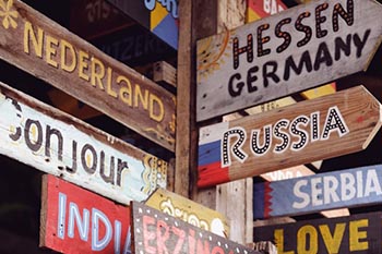 a bunch of wooden signs that are on a pole directing to countries all over the world